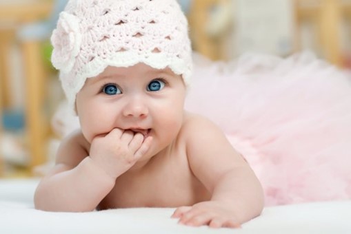 Baby with white hat biting hand - Baby Journey