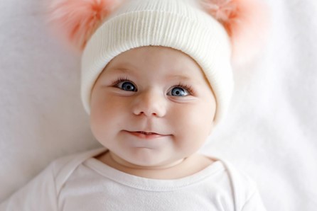 Baby with white hat smiling - Baby Journey