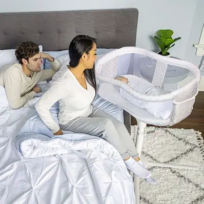 Mother exiting the bed by rotating Halo bassinest swivel sleeper essentia - Halo Bassinet review - Baby Journey