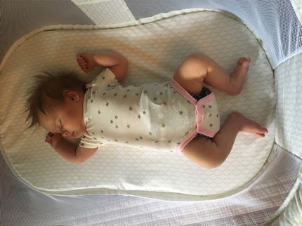 Newborn sleeping on firm waterproof mattress in Halo crib - HALO Bassinest Swivel Sleeper Essentia Review - Baby Journey