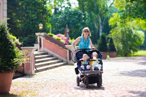 Woman in The Park With Double Stroller and Her Babies | Best Double Stroller for Travel | Baby Journey