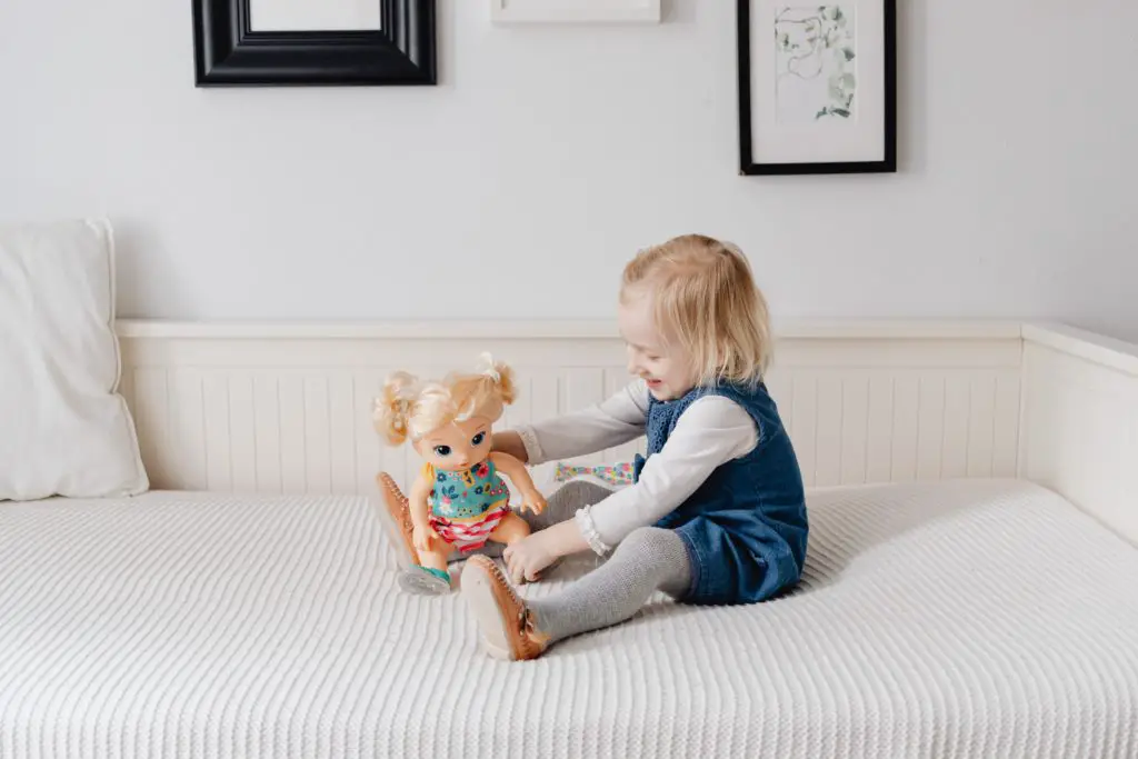 Girl toddler playing with toy instead of sleeping in bed. - Toddler won't stay in bed at bedtime - Baby Journey blog