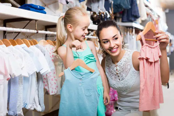 Mother helping daughter with shopping for trendy kids outfits - Stylish kids, fashionable kids - Baby Journey blog