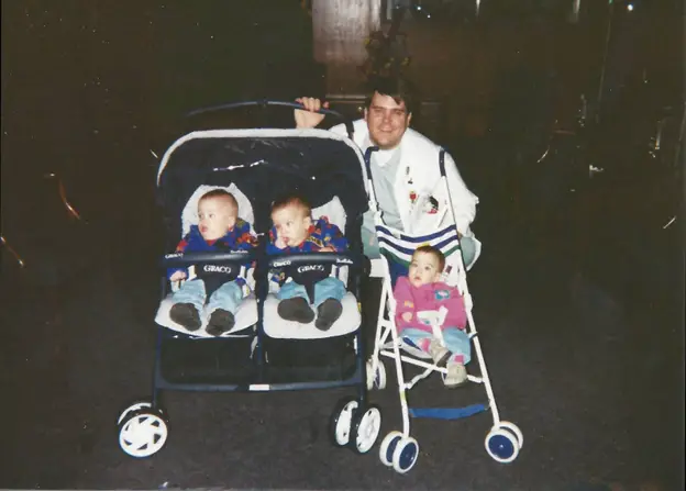 A father posing with three babies in 1990s strollers - When Were Strollers Invented History of Baby Strollers – Baby Journey