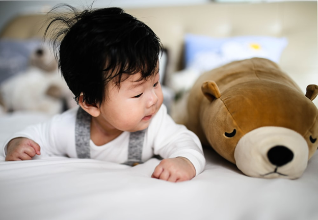 Young Asian baby boy looking at plush toy while having tummy time - Simple Gross Motor Activities for Infants - Baby Journey