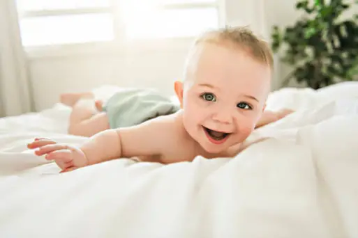 Baby having tummy time on the bed - Baby skip crawling, Baby Walking Before Crawling - Baby Journey