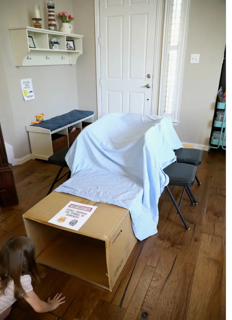 At home obstacle course for kids made with cardboard boxes, chairs and blankets - Best Toddler Obstacle Course Ideas to Build Your Child's Gross Motor Skills - Baby Journey