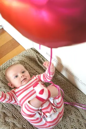 Baby doing balloon kicking activity - Simple Gross Motor Activities for Infants - Baby Journey