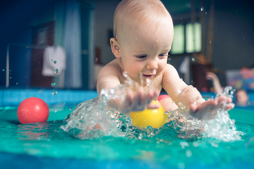 Cute baby playing with water and bath toys - Simple Gross Motor Activities for Infants - Baby Journey