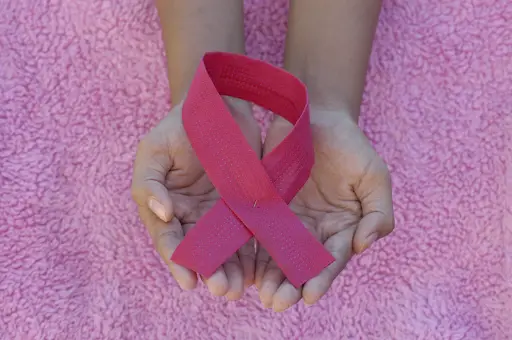 Pink Ribbon in open palms - Breastfeeding after breast cancer treatment - Baby Journey