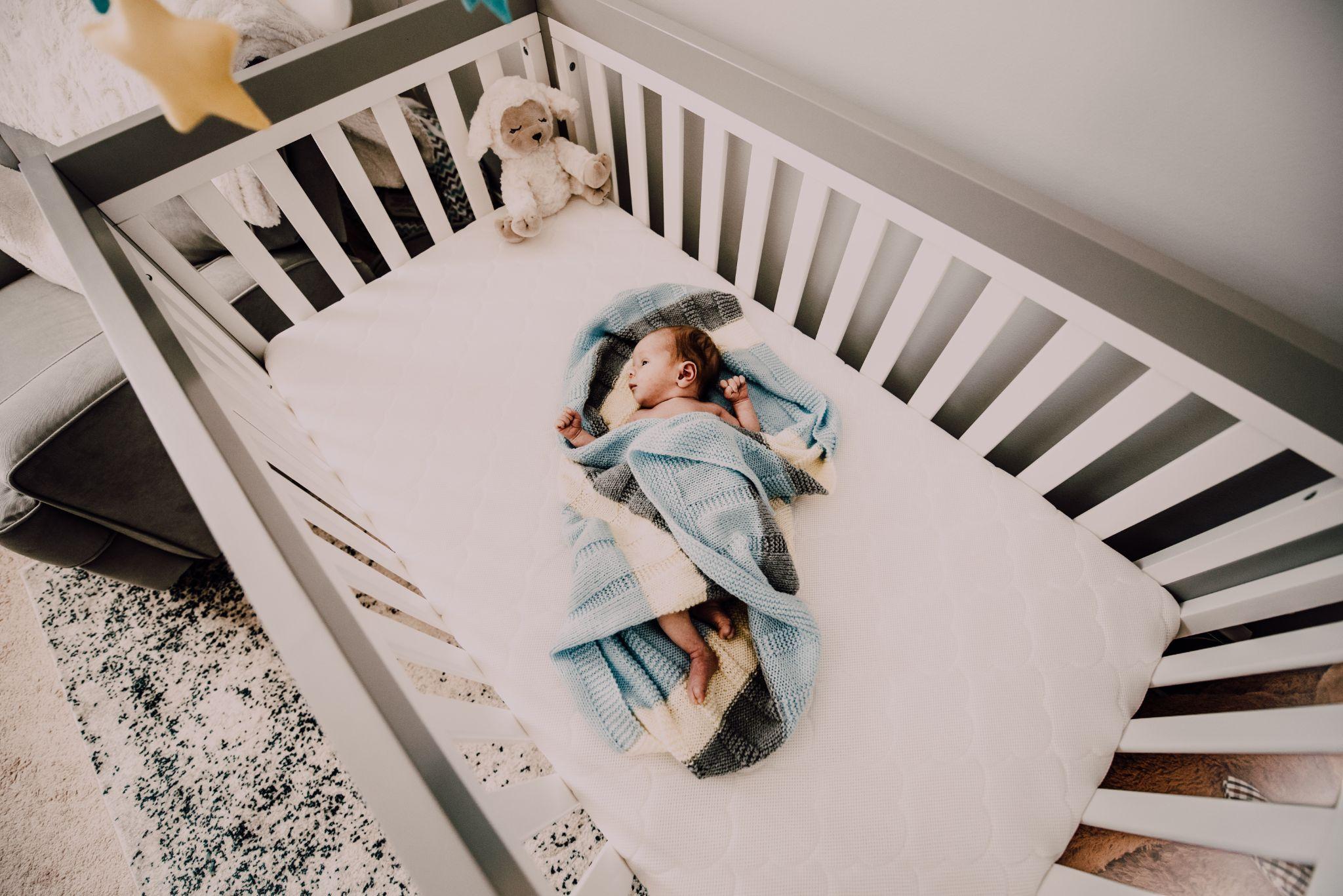 Photo of a baby resting in a baby crib - how to make baby more comfortable in crib - Baby Journey