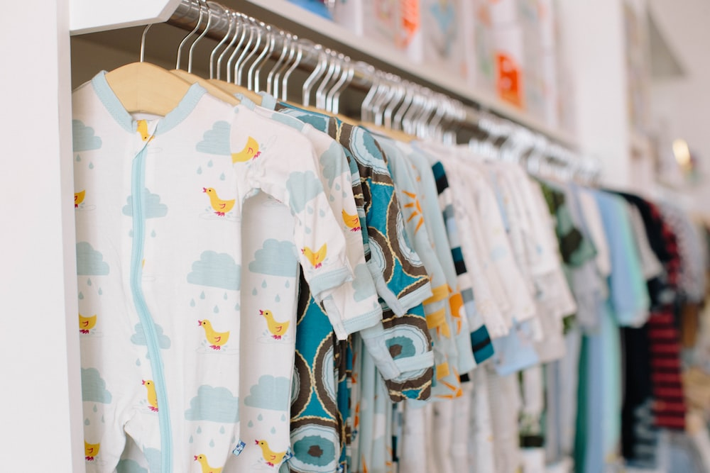 A wardrobe of hanging newborn clothes - Best unique baby gifts for new parents - Baby Journey
