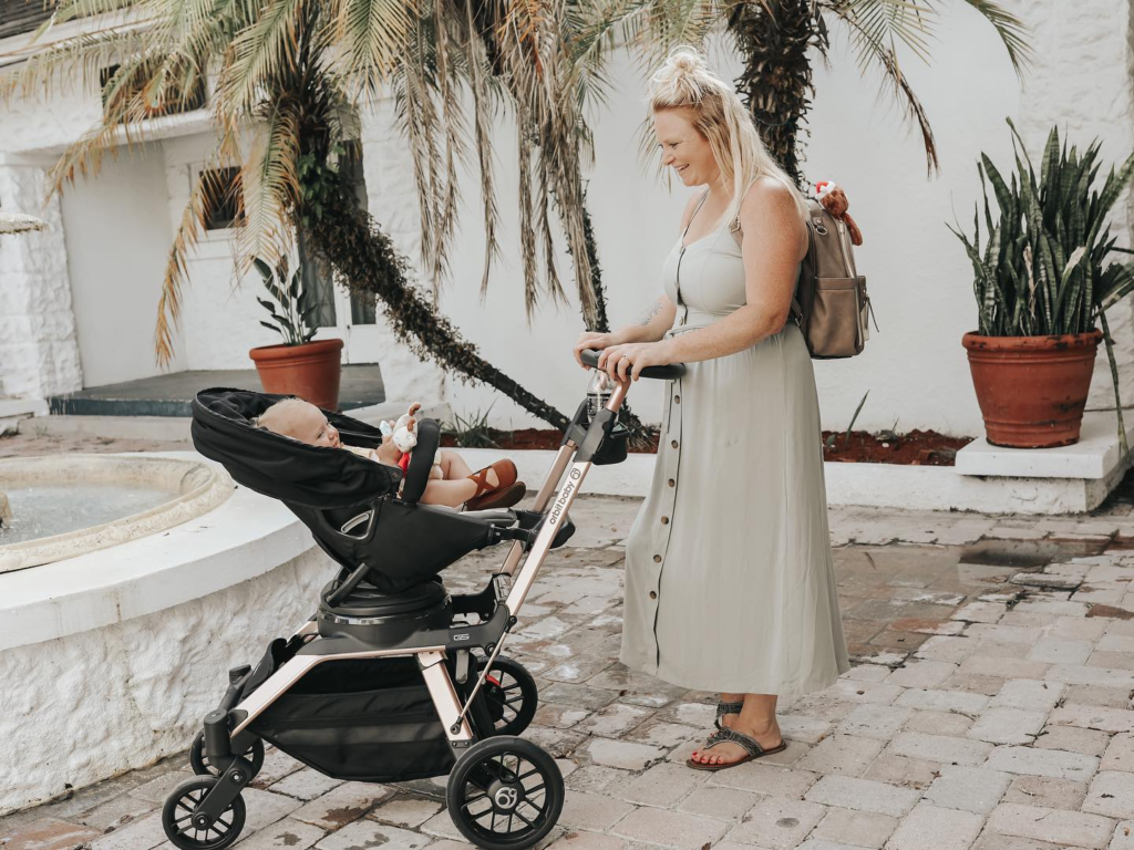 A mother pushing an Orbit Baby G5 stroller with baby in it - Orbitbaby Stroller Review - Baby Journey