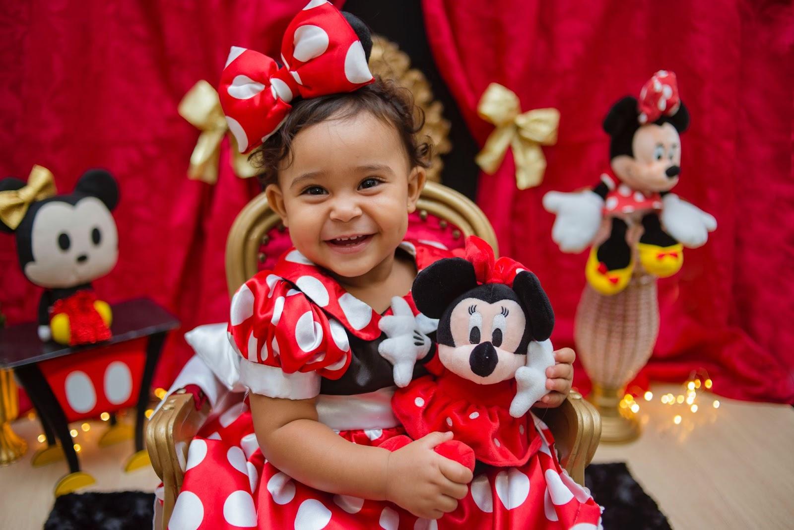 Little girl wearing red dress with white polka dots resembling Minnie Mouse outfit against Disney inspired backdrop - Disney Baby Names - Baby Journey