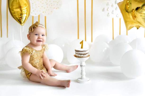 Baby girl dressed in gold dress at her baptism and the first birthday celebration. - Tips for Baptism Invitation Wording - Baby Journey