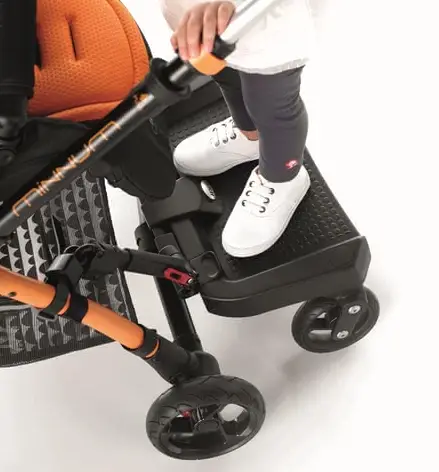 Closeup photo of an unknown toddler standing on a buggy board attached behind a baby stroller - Best Stroller Boards - Baby Journey