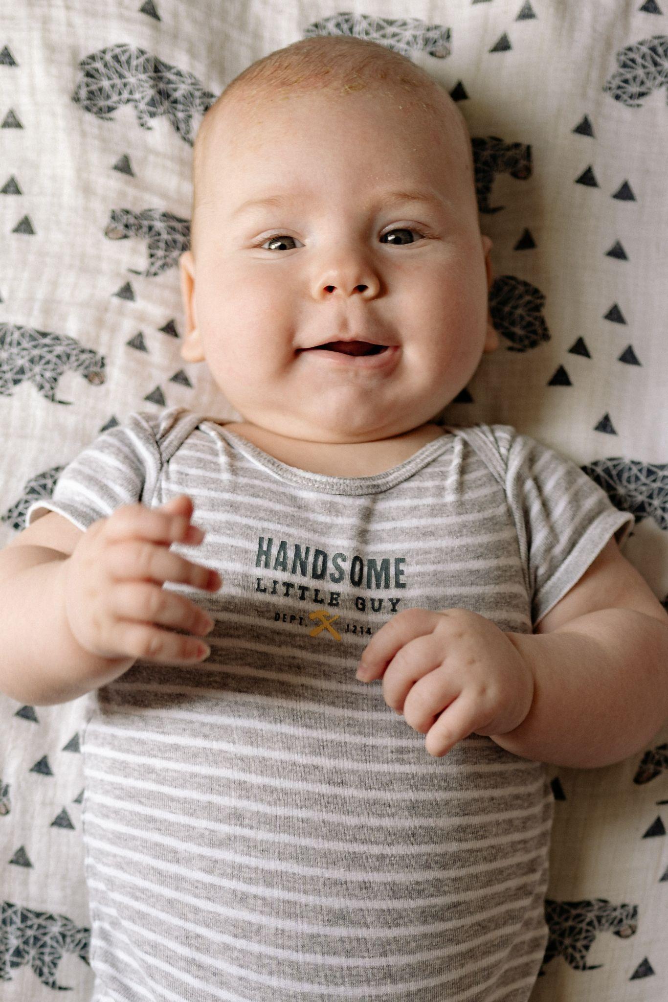 Baby boy wearing a onesie that included the sentence “handsome little guy” - Funny Baby Onesies - Baby Journey