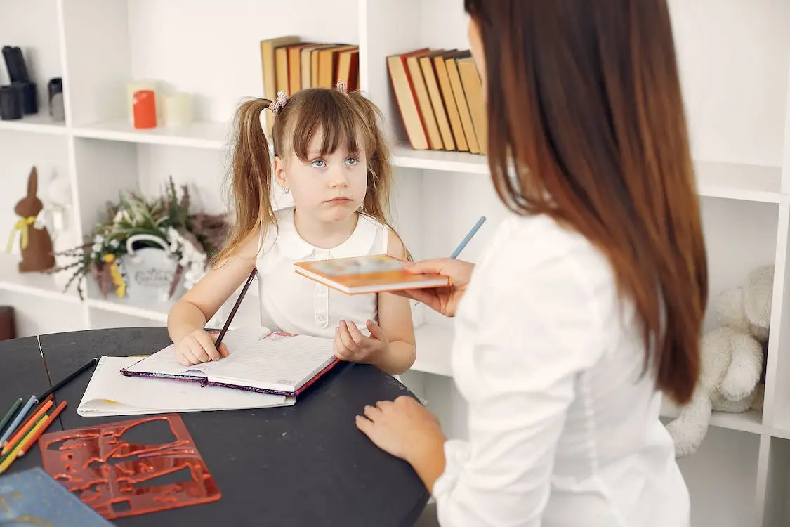 A home tutor giving assignment to a young girl - 10 Tips For Selecting The Best Home Tutor For Your Kid - babyjourney.net