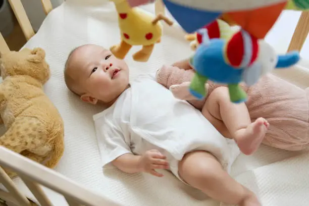Baby looking at toys hanging above the bassinet - Baby Won't Sleep in Bassinet - Baby Journey