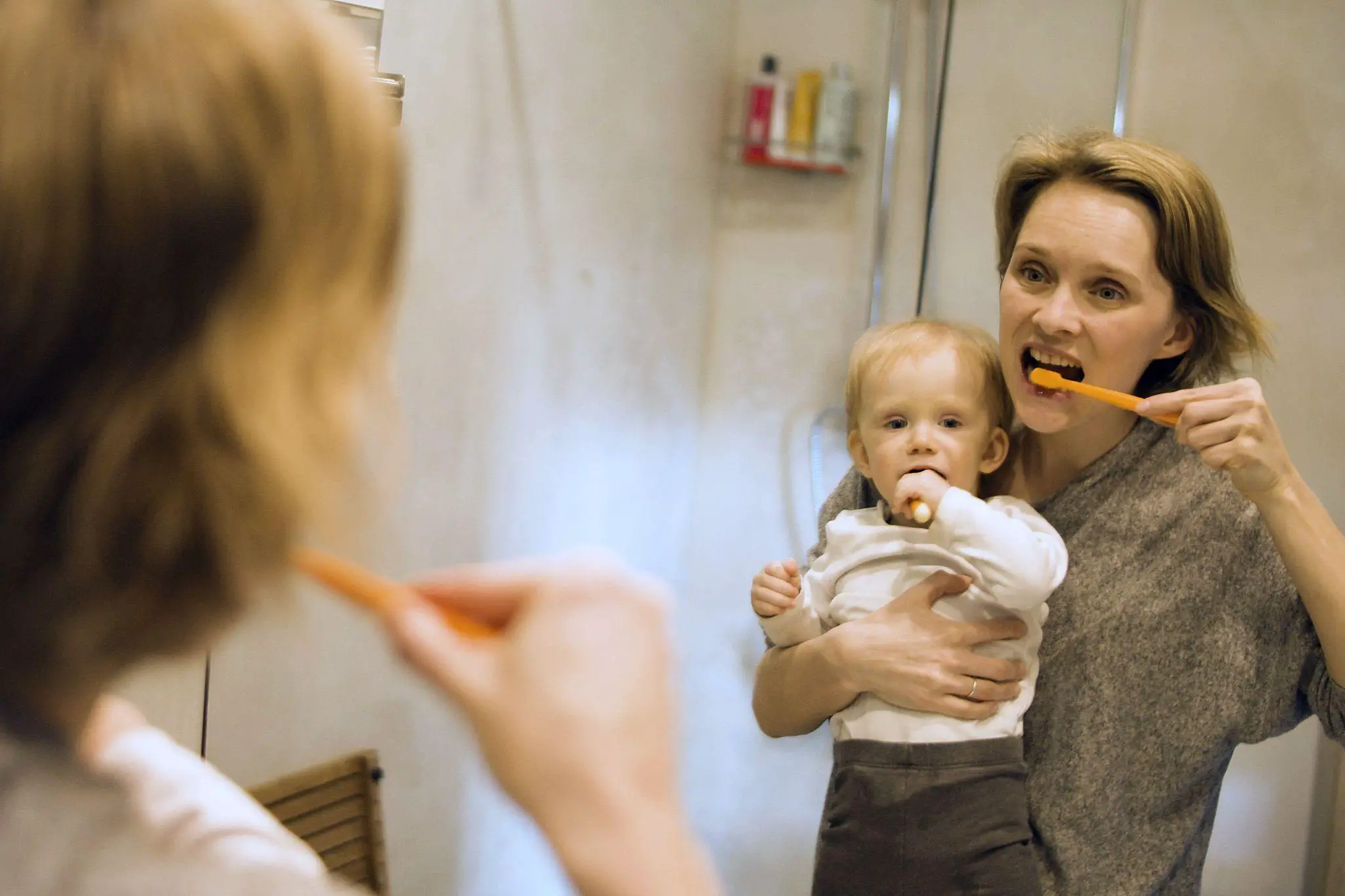 Mom and child brushing teeth in front of the mirror - When Do Babies Recognize Themselves in the Mirror - Baby Journey 