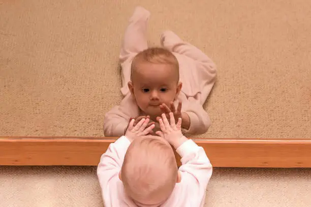 Baby high-fives herself in the mirror - When Do Babies Recognize Themselves in the Mirror - Baby Journey 