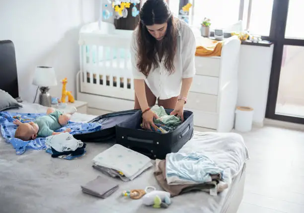 A mother is packing the luggage - How to Travel with Formula - Baby Journey
