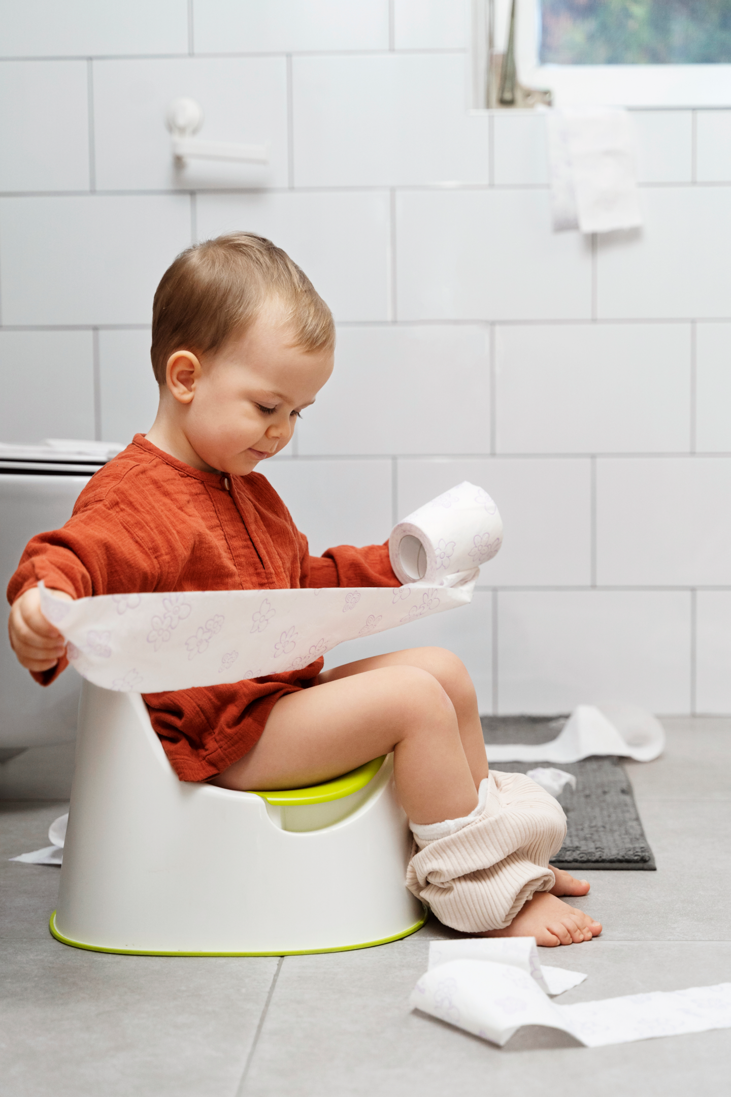 Baby with toilet roll on the potty- How to Potty Train a Stubborn Toddler: Expert Tips and Tricks Feature Image - Baby Journey