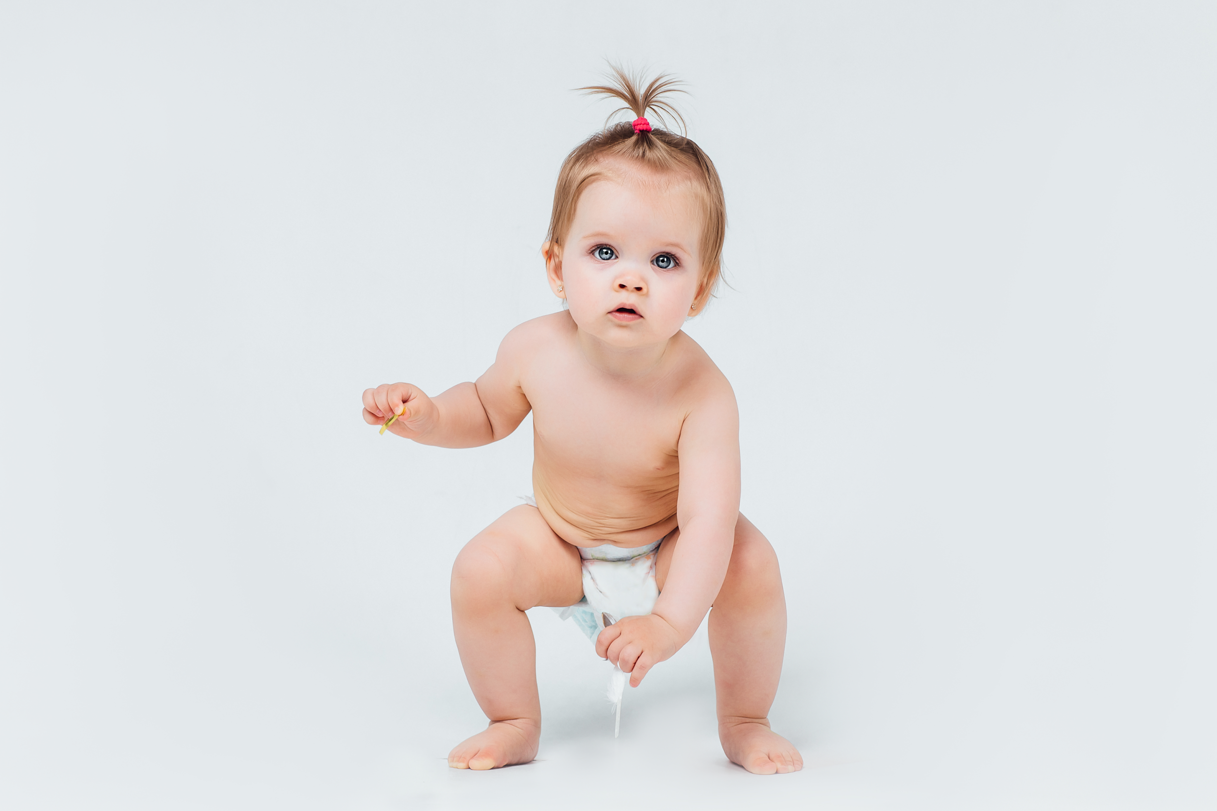 Baby getting ready to take of his diaper - How to Potty Train a Stubborn Toddler: Expert Tips and Tricks Feature Image - Baby Journey