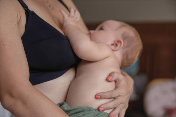 Mom breastfeeds baby in nursing bra - How Many Nursing Bras Do I Need - Baby Journey