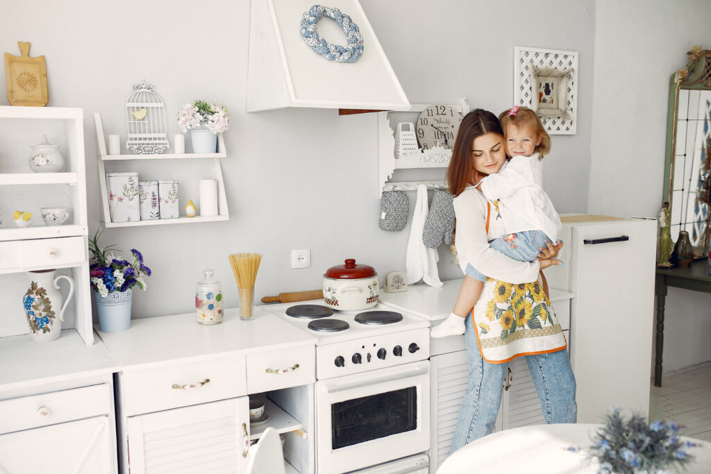  A mother carrying a little girl in the kitchen - How to Set Up a Childproof Kitchen - babyjourney.net