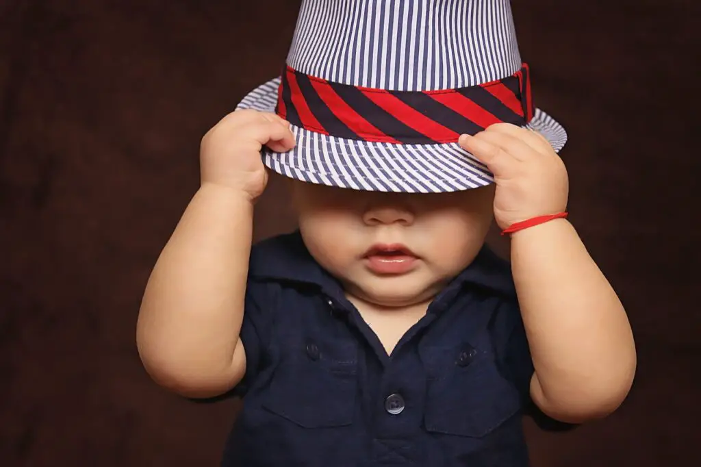 A boy wearing a hat in a dark room - 250+ Old Lady Names We Adore For Their Classic Elegance - Baby Journey