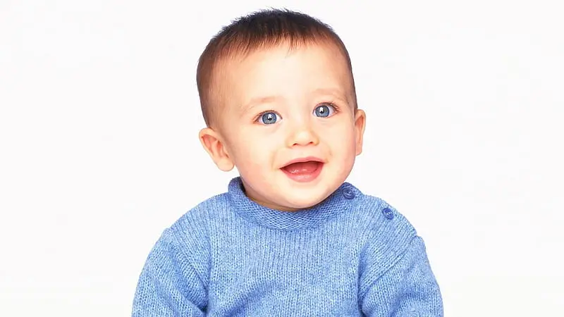 Little baby boy dressed in blue clothes smiling - Best Names That Mean Blue for Girls and Boys - babyjourney.net
