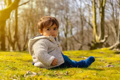 Cute baby boy sitting in a park - 230+ Ethereal Names for Girls and Boys - babyjourney.net