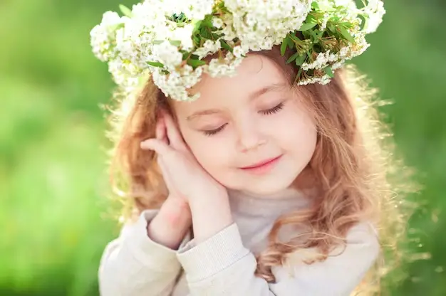 A pretty little girl with a flower crown on her head - 230+ Ethereal Names for Girls and Boys - babyjourney.net