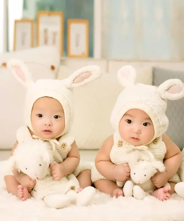Two babies are holding dolls with white rabbit cloth - 230+ Middle Names for Maeve - BabyJourney