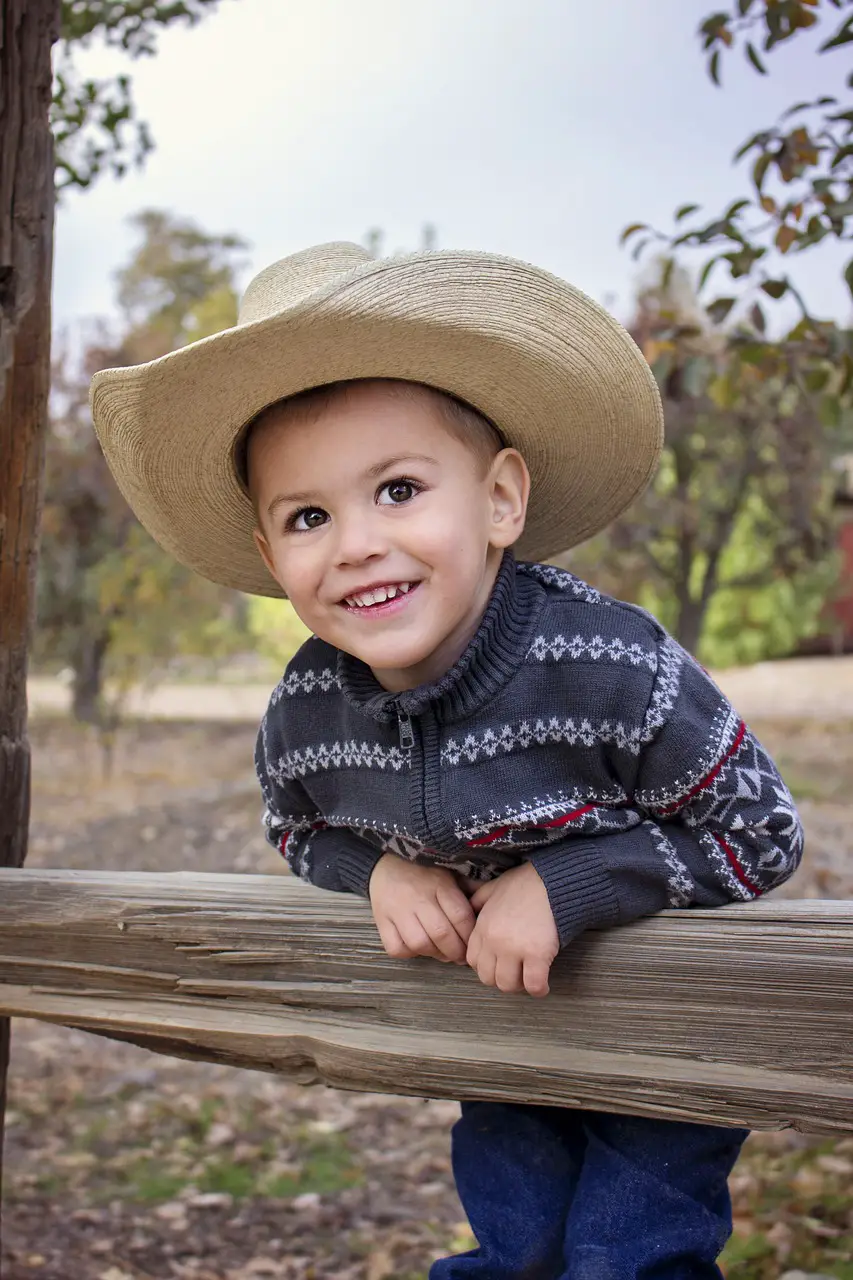 A cowboy-dressed kid glances at the camera -500+ Cowboy Names to Name Your Child - Baby Journey