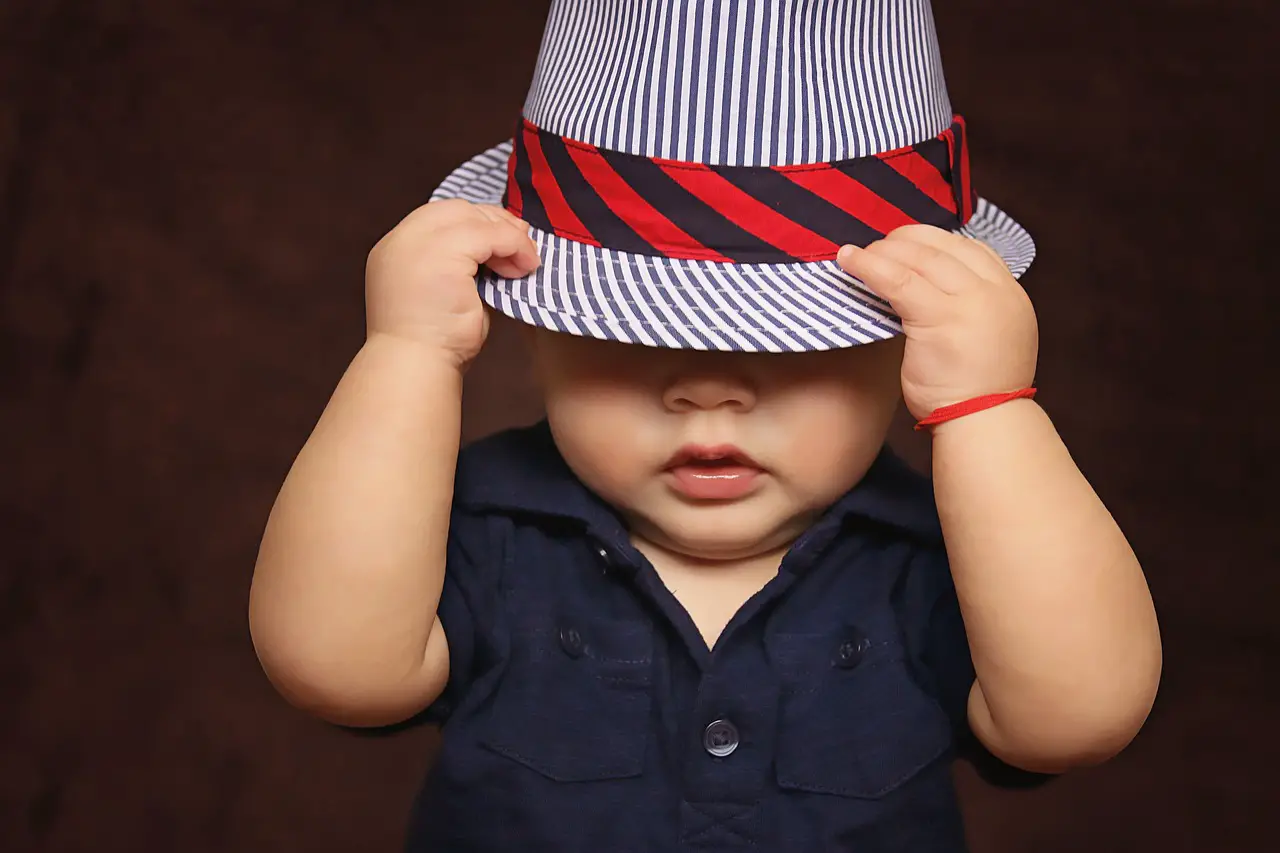 Cool little baby boy pulling down his hat - 500+ Cowboy Names to Name Your Child - Baby Journey